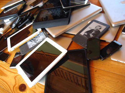 A jumbled pile of phones, tablets, e‐readers.